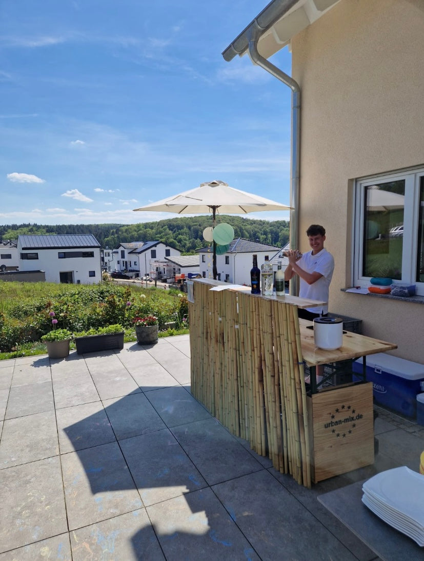 Cocktailbar von urban-mix.de von der Seite. Mobile Cocktailbar steht im Garten für eine Geburtstagsfeier.